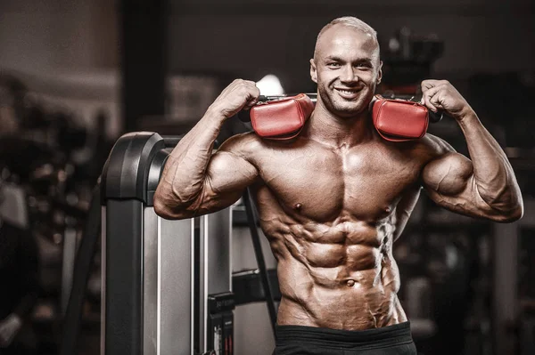 Knappe sterke atletische man pompt spieren workout fitness — Stockfoto