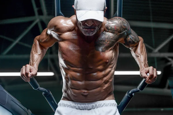 Hombres atléticos guapos bombeando músculos flexiones en barras irregulares — Foto de Stock