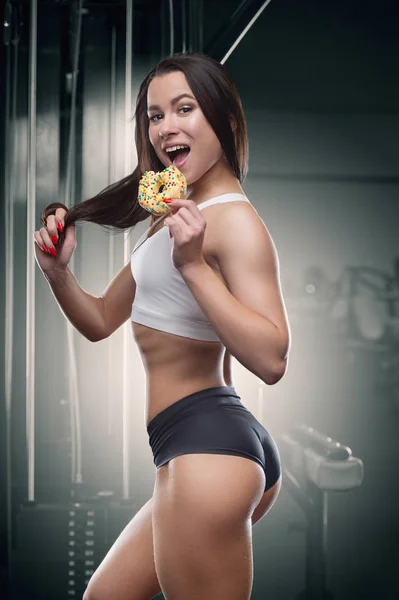 Mulher fitness com donut no treino no ginásio — Fotografia de Stock