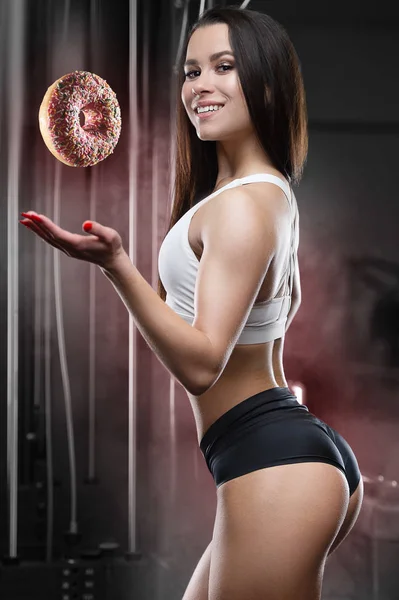 Mulher fitness com donut no treino no ginásio — Fotografia de Stock