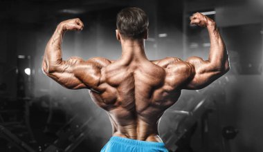 Bodybuilder strong man pumping up biceps muscles