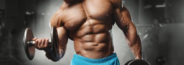 Bodybuilder strong man pumping up biceps muscles