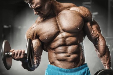 Bodybuilder strong man pumping up biceps muscles