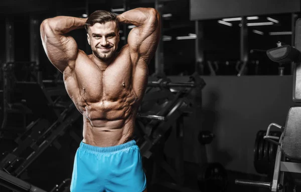 Bodybuilder strong man pumping up abs muscles — Stok fotoğraf