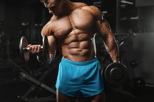 Bodybuilder strong man pumping up biceps muscles — Stock Photo, Image