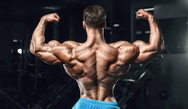 Culturista hombre fuerte bombeando los músculos del bíceps —  Fotos de Stock