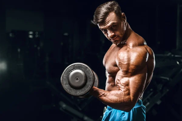 Bodybuilder strong man pumping up biceps muscles — Stock Photo, Image