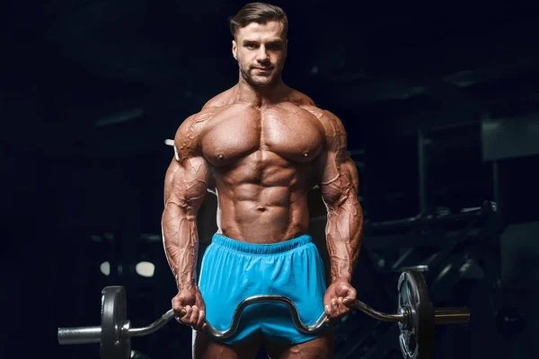Bodybuilder strong man pumping up biceps muscles — 스톡 사진