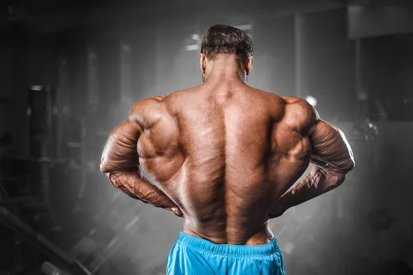Kulturysta silny człowiek pompujący mięśnie bicepsów — Zdjęcie stockowe