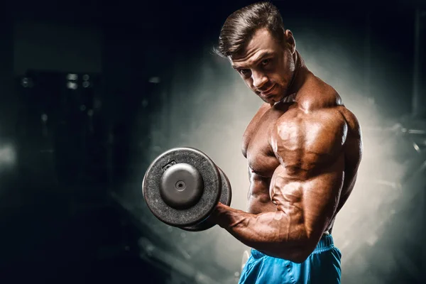 Bodybuilder strong man pumping up biceps muscles — 图库照片