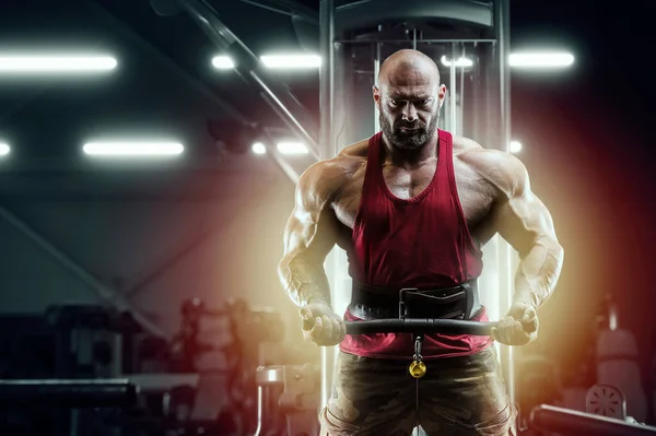 Fisiculturista homem forte bombeando músculos do bíceps — Fotografia de Stock