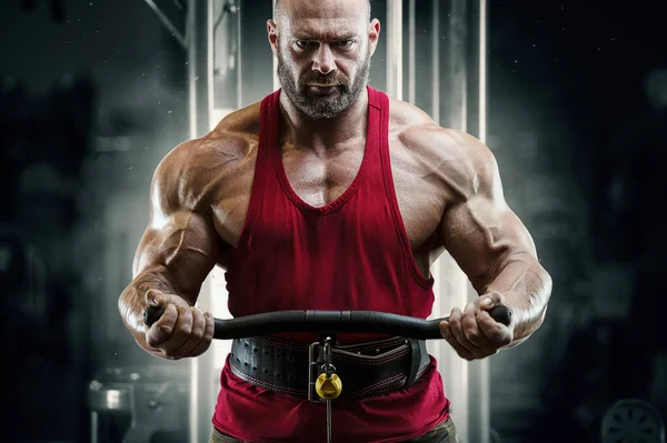 Culturista hombre fuerte bombeando los músculos del bíceps — Foto de Stock