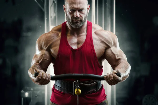 Culturista hombre fuerte bombeando los músculos del bíceps — Foto de Stock