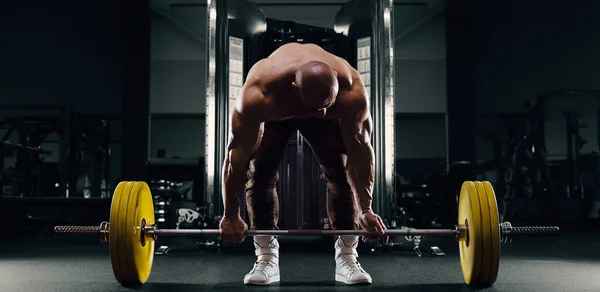 Vücut geliştiren atletik adam sırt kasları kaldırıyor. — Stok fotoğraf