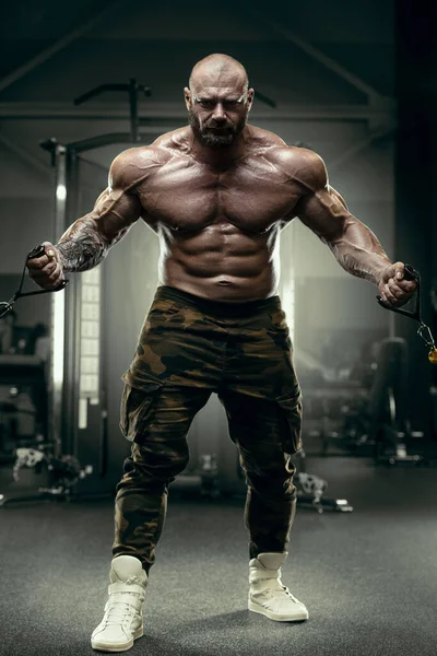 Bodybuilder starker Mann, der die Bizeps-Muskeln aufpumpt — Stockfoto