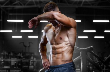 Vücut geliştiren yakışıklı, güçlü, atletik yakışıklı, kas geliştiren, vücut geliştiren sağlıklı bir vücut geliştirme uzmanı. Kas geliştiren, spor salonunda çıplak vücut egzersizleri yapan adamlar.