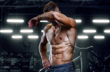 Vücut geliştiren yakışıklı, güçlü, atletik yakışıklı, kas geliştiren, vücut geliştiren sağlıklı bir vücut geliştirme uzmanı. Kas geliştiren, spor salonunda çıplak vücut egzersizleri yapan adamlar.