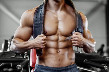 Vücut geliştiren yakışıklı, güçlü, kaslarını şişiren, kas geliştiren, vücut geliştiren, spor kemeri geliştiren, kaslı spor yapan, karın egzersizi yapan, çıplak vücutlu, kaslı sporcu.