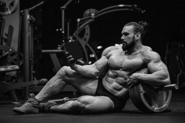トレーニングフィットネスとボディビルディングの健康的なコンセプトの背景の後にタンパク質粉末と強力な運動神経の男を構築 ジム裸の胴で演習を行う筋肉フィットネスの男性 — ストック写真