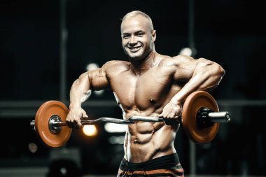 Vücut geliştiren yakışıklı, güçlü, atletik, kas geliştiren, spor yapan, vücut geliştiren, sağlıklı bir konsept geçmişi olan, spor salonunda çıplak bedende kol egzersizi yapan, kaslı, formda adamlar.