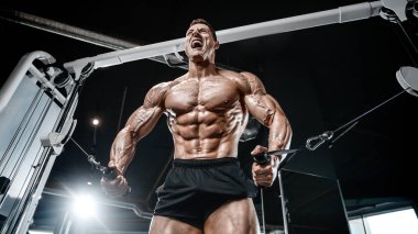 Kablolu TV 'deki kaslı vücut geliştirici fitness adamları kaslarını şişiriyor. Vücut geliştirme egzersizleri ve vücut geliştirme konsepti - Spor salonunda çıplak vücut egzersizleri yapan yakışıklı atletik erkekler
