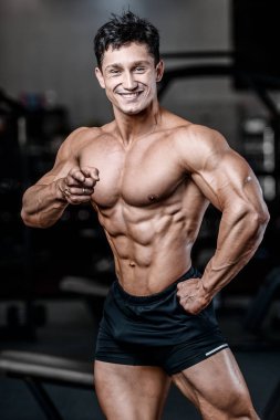 Vücut geliştiren yakışıklı, güçlü, atletik, kas geliştiren, spor yapan, vücut geliştiren, sağlıklı bir konsept geçmişi olan, spor salonunda çıplak bedende kol egzersizi yapan, kaslı, formda adamlar.