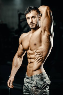 Vücut geliştiren yakışıklı, güçlü, atletik, kas geliştiren, spor yapan, vücut geliştiren, sağlıklı bir konsept geçmişi olan, spor salonunda çıplak bedende kol egzersizi yapan, kaslı, formda adamlar.