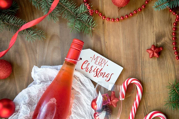 Gül şarabı şişesi ve kırmızı Noel süsü 