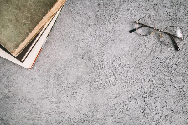 Eski kitaplar ve bardaklar masanın üzerinde. Metinler için yer