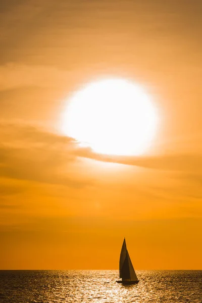 Sailboat sailing on the ocean in a tropical sunset