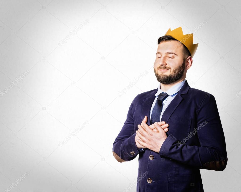 The concept of leadership, excellence. Portrait of a smiling man with a golden crown on his head.