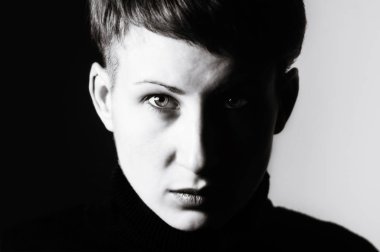 Siyah ve beyaz bir kızla ciddi bakışları portresi.