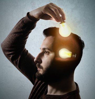 Adam bir ampul kafasında giyiyor. Yeni fikir kavramı.