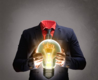 İş adamı elinde yeni bir fikirle bir lamba tutuyor. Yeni bir fikir, yeni bir keşif kavramı.