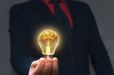 İş adamı elinde bir lamba tutuyor ve önünde yeni bir 2020 yılı var. Yeni fikirler kavramı yeni keşifler.