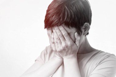 Korku kavramı, utanç, aile içi şiddet. Kadın ellerini beyaz arka planda gizliyor. Siyah ve beyaz resim.