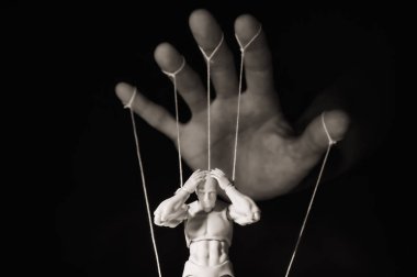 Kontrol kavramı. Marionette insan elinde. Siyah ve beyaz resim