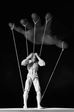 Concept of control. Marionette in human hand. Black and white image clipart