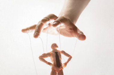 Kontrol kavramı. Marionette insan elinde. Resim beyazda.