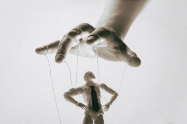 Kontrol kavramı. Marionette insan elinde. Siyah ve beyaz resim.