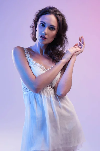 Belle femme en robe blanche et lumière bleue — Photo