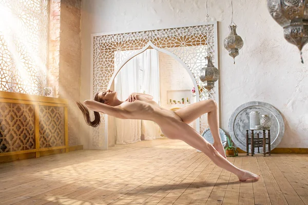 Güneş ışığı ile dolu odasında Levitating güzel çıplak kadın