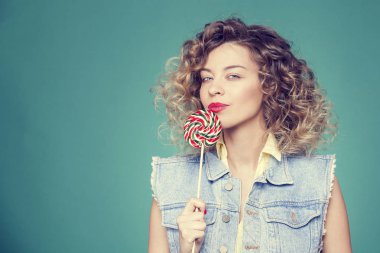 Genç kadın lolipopla poz veriyor.