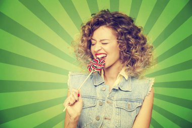 Genç kadın lolipopla poz veriyor.