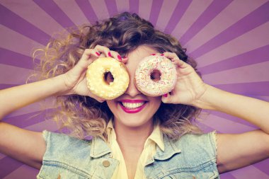 Kıvırcık kız yüz soyulmuş mor zemin üzerine çörek ile gizleme