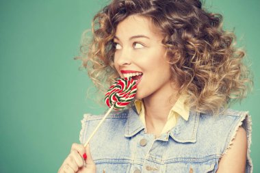 Genç kadın lolipopla poz veriyor.