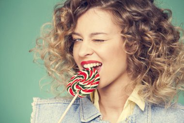 Genç kadın lolipopla poz veriyor.