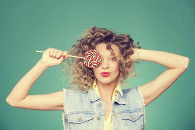 Genç kadın lolipopla poz veriyor.