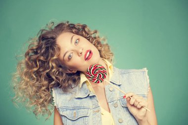 Genç kadın lolipopla poz veriyor.