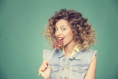 Genç kadın lolipopla poz veriyor.